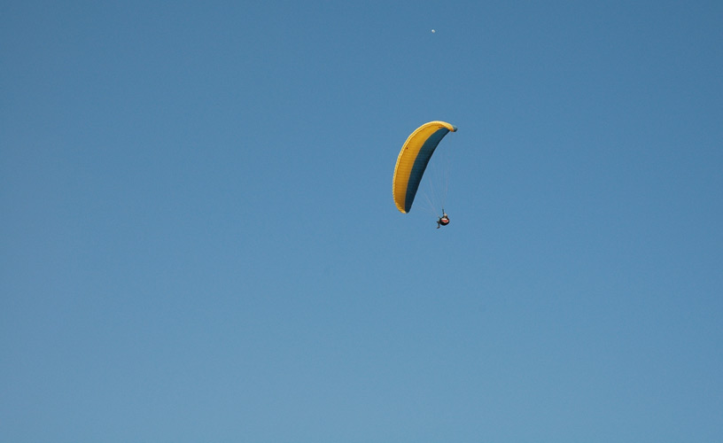 Colorful paragliders that drew shapes on the cloudless sky