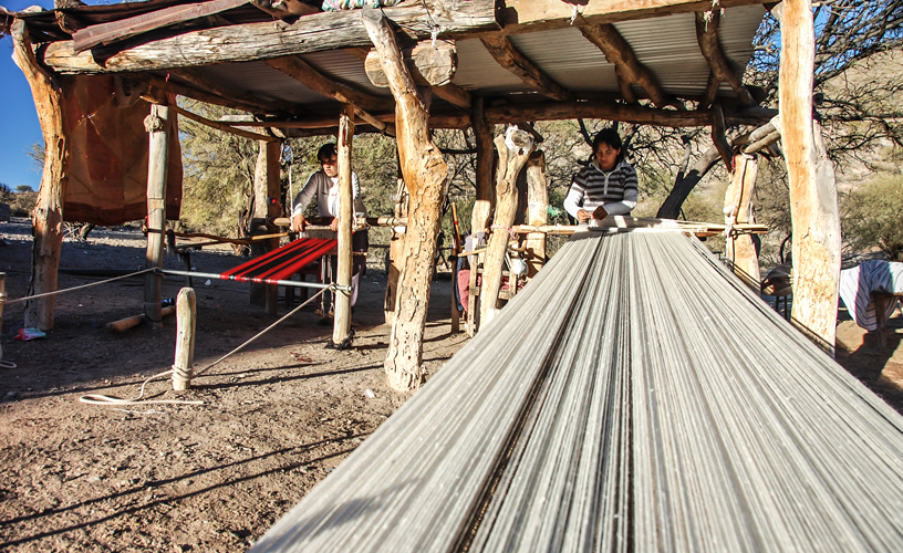 Weavers in charge of huge looms